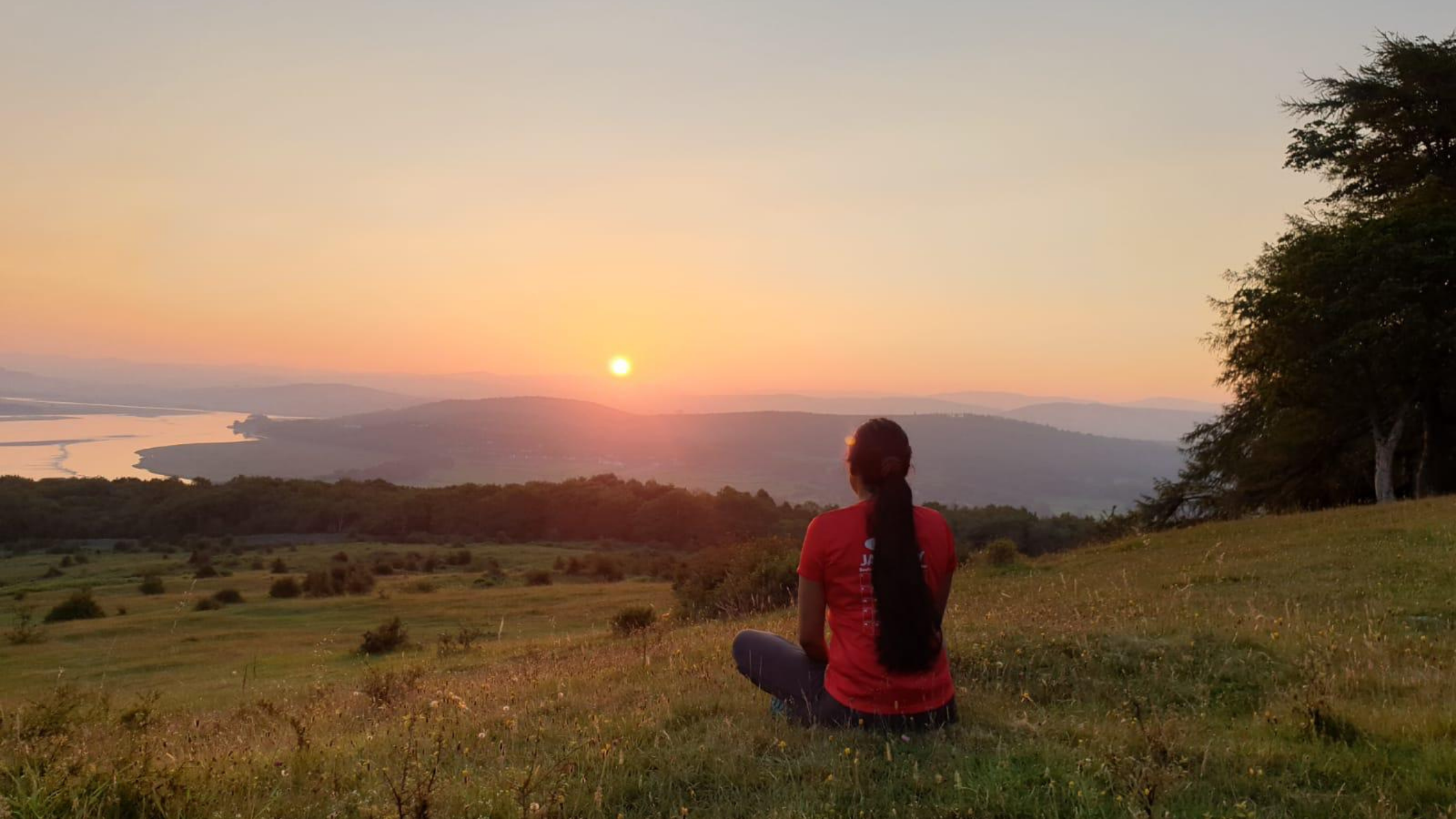 Muslim woman sitting on a high fell enjoying the sunset