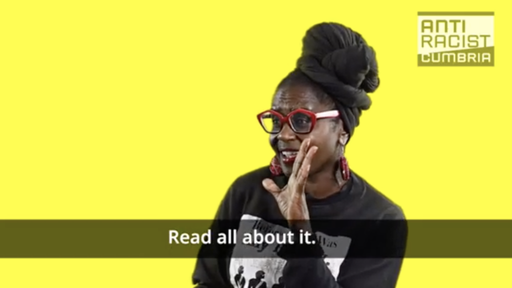 Janett, a black woman with red glasses puts her hand to her mouth as if to shout. Text: "Read all about it" on a yellow background.