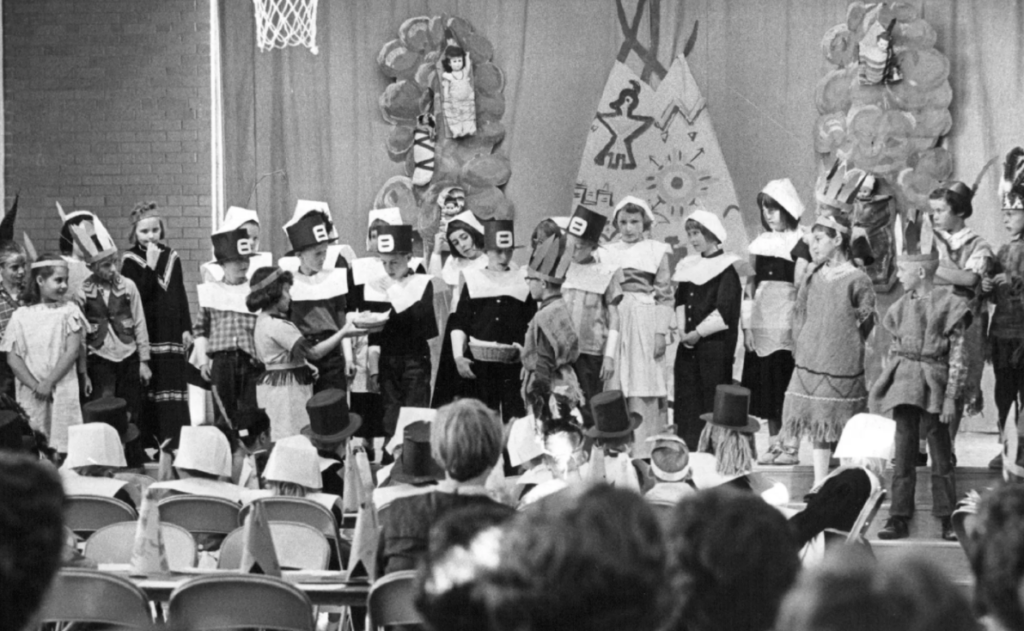 Black and white image of schoolchildren acting in a "First Thanksgiving" play.
