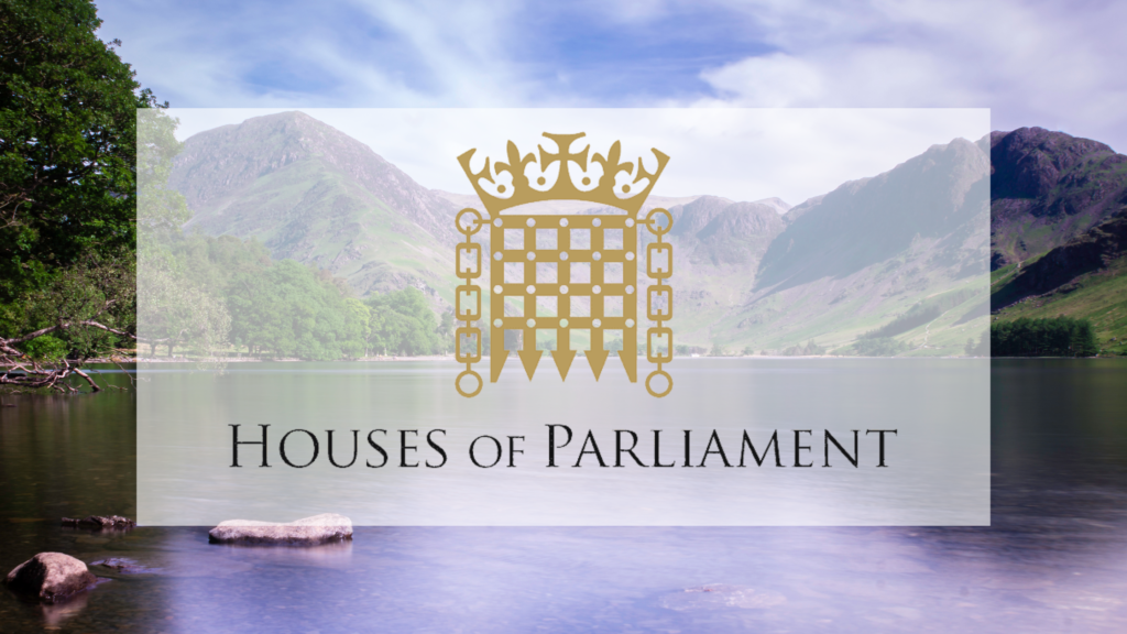 Text and image of The Houses of Parliament with the drawbridge and crown symbol. Background image of lake and fells.