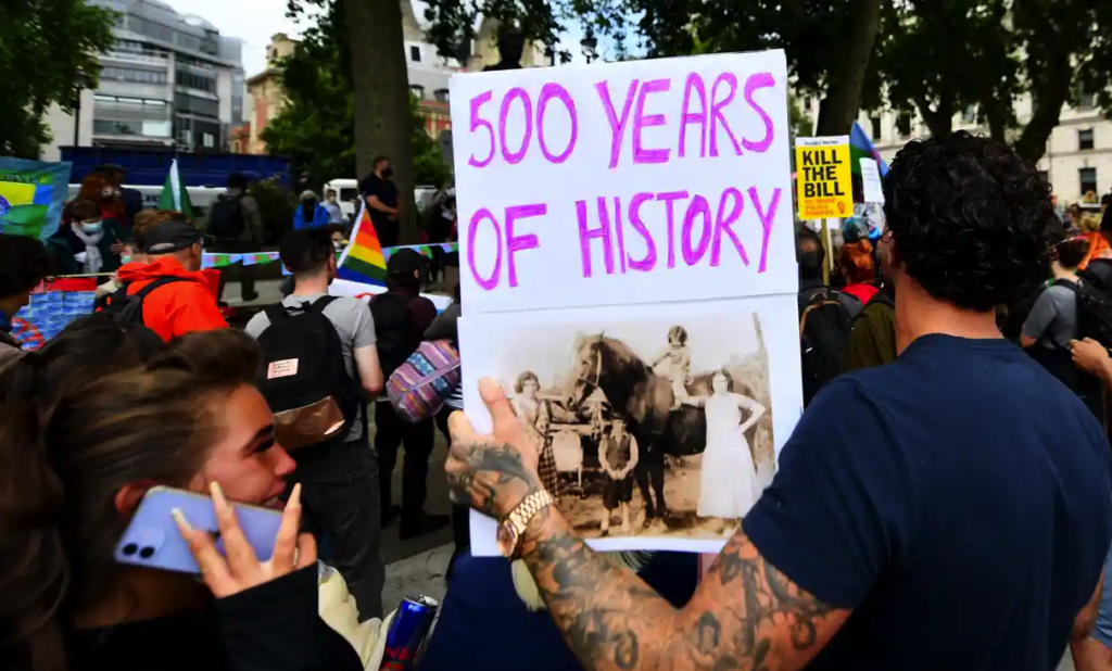 Gypsy, Roma and Travellers protest holding a plaque reading "500 years of history".