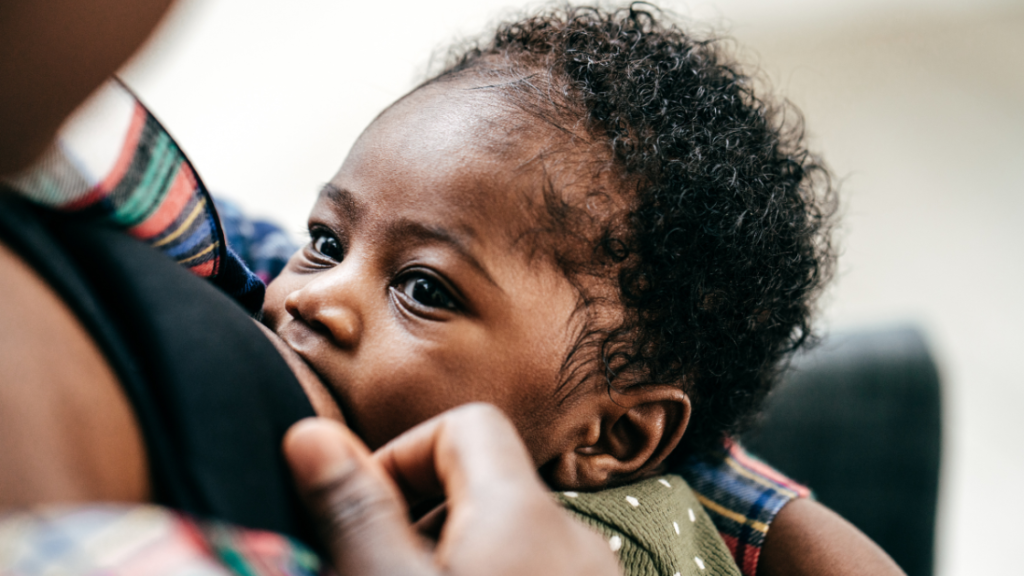 A black woman breastfeeds her black child.
