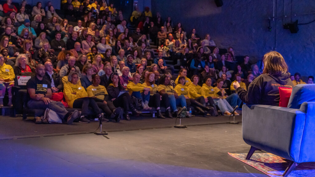 A full auditorium of people from a variety of backgrounds.