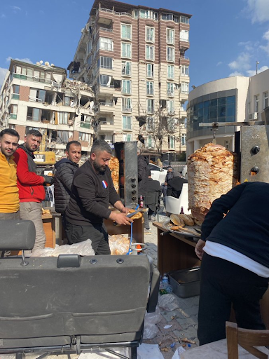 Five men in an outdoor makeshift kitchen