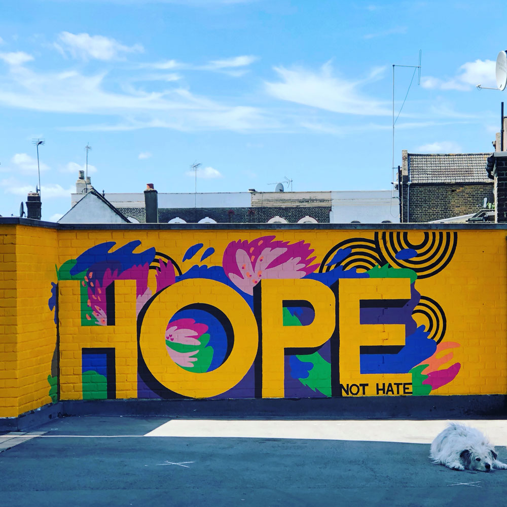 Bright orange mural with HOPE NOT HATE written in capital letters.